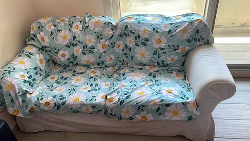 2-seater white fabric sofa with floral slipcover — good condition