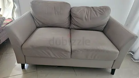 Two-seater light brown leather sofa in good condition