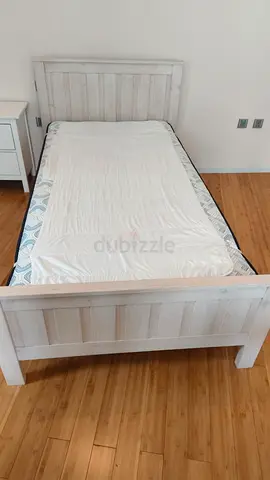Single white wooden bed frame with headboard and footboard and mattress