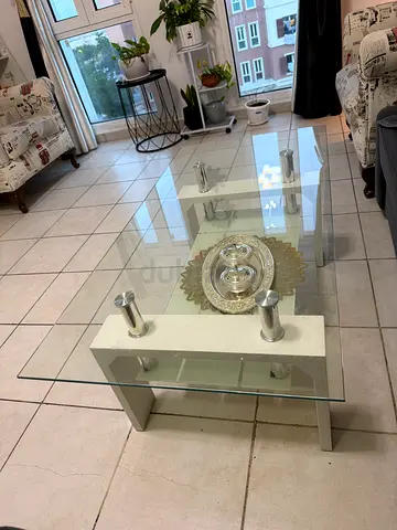 Modern glass coffee table with white base and metal accents