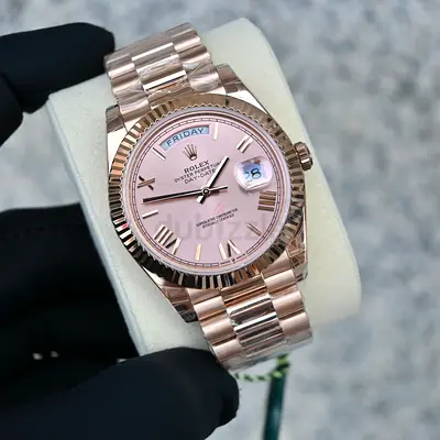 The image shows a Rolex Day-Date 40 in 18 ct Everose gold featuring a sundust dial with Roman numera