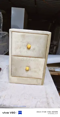 Small two-drawer bedside cabinet in cream velvet with gold knobs