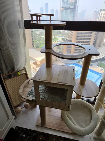 Wooden multi-level cat tree house with cozy bed and scratching posts