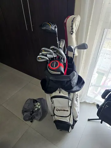 Big bundle of golf clubs including golf balls