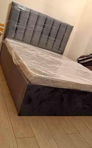 Grey upholstered queen size bed with storage including mattress