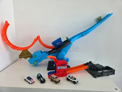 Hot Wheels Track Set with Dinosaur Loop and 4 Toy Cars, construction crane, shark truck and robot
