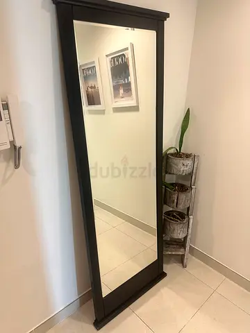 Full-length freestanding mirror with dark wood frame