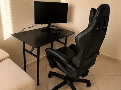 Black gaming/office chair with compact black desk