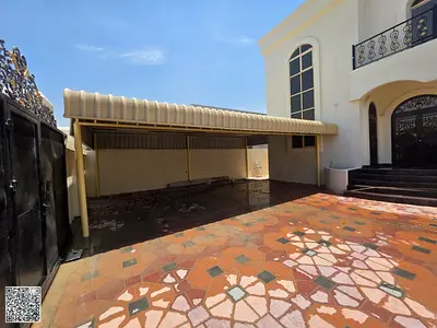 Villa for annual rent in Al Rawda, Ajman, with a built-up area of 5,000 sq. ft., consisting of 5 bedrooms, a majlis, and a spacious living hall.