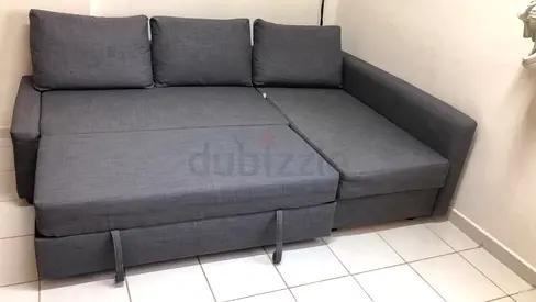 Grey L-shaped sofa bed in good condition