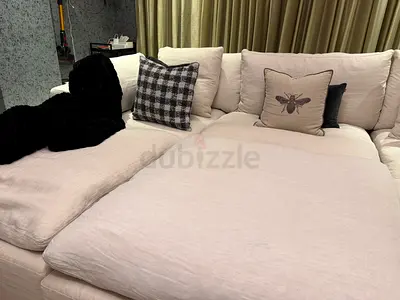 Large L-shaped beige fabric sofa with deep cushions