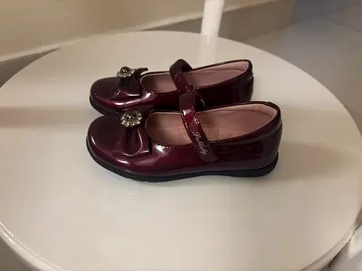 Dark red shoes with a small flower on it size 27