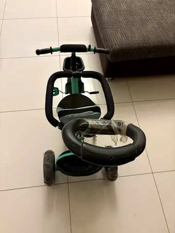 Mint green kids tricycle with parent push handle — good condition