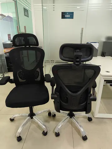 Pair of ergonomic black mesh office chairs with headrests