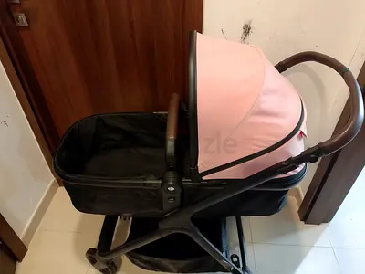 Lightly used pink bassinet stroller/pram with storage basket