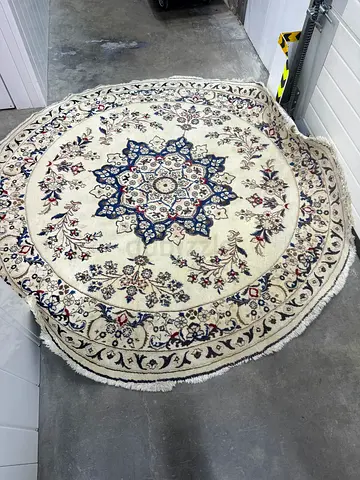Round white wool rug with traditional navy medallion pattern