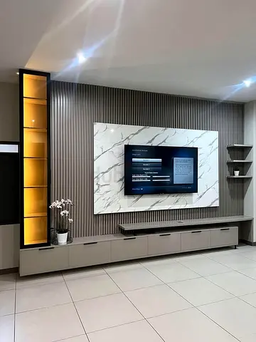 Modern built-in entertainment unit with marble sheet TV backdrop and storage