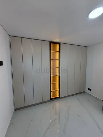 Built-in Beige Wardrobe with Central Display Shelves and Lighting