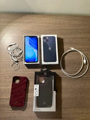 iPhone 13 Midnight with the original box, charger, headphones, and phone covers.