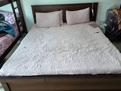 Queen-size wooden bed frame with headboard and mattress