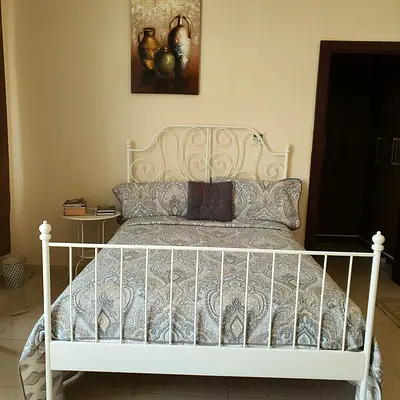 White Metal Double Bed Frame with Headboard and Footboard with a mattress and a small white table