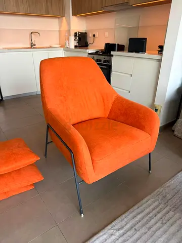 Orange upholstered armchair with metal legs