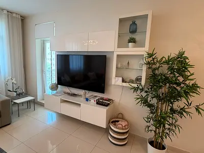 White wall-mounted entertainment unit with shelving and storage