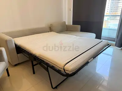 Light grey L-shaped sofa bed with pull-out mattress (good condition)