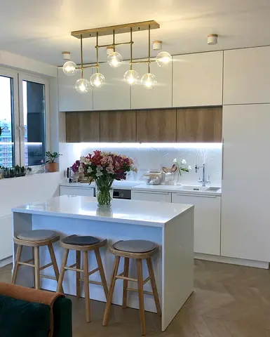 Modern white kitchen island with 3 wooden stools and pendant light