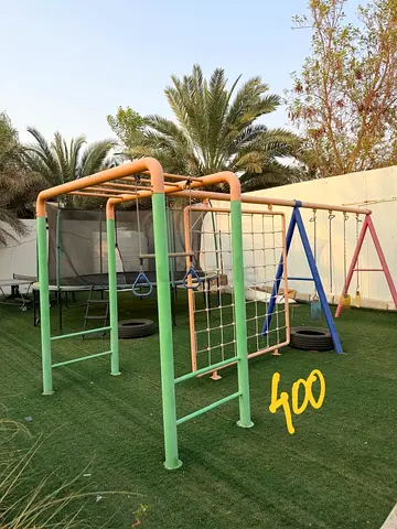 Outdoor kids playset with swings, monkey bars and climbing net