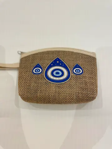 Small jute wrist pouch with evil eye design — lightly used
