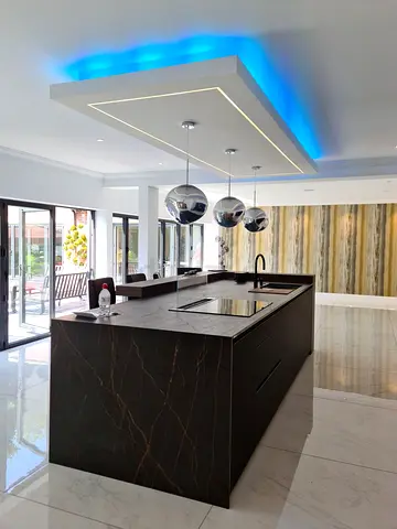 Modern black marble kitchen island with integrated sink and induction hob