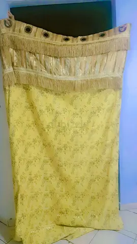 Yellow floral curtain panel with decorative fringe and eyelets