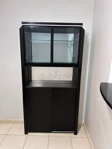 Dark wood display cabinet with glass shelves and lower storage