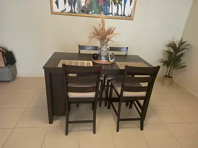 Dark wood 4-seater dining table set with inbuilt wine rack and cushioned chairs.