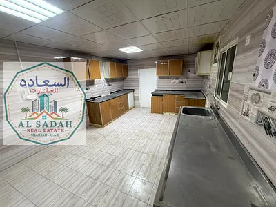 A house for rent, divided into two sections. The first section has 4 bedrooms, a living room, a majlis (formal sitting room), a kitchen, and 3 bathrooms. The second section has 2 bedrooms, a living ro
