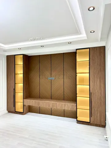 Custom built-in wooden entertainment/storage wall with illuminated display cabinets