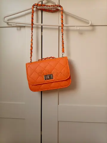 Small quilted orange crossbody bag with chain strap