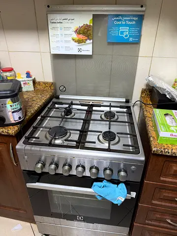 Stainless steel 4-burner gas stove with built-in oven - good condition