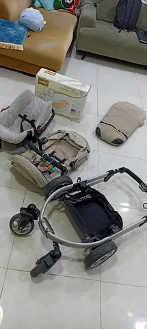 Complete beige travel stroller frame with bassinet and car seat attachments - used