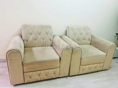 Pair of beige upholstered armchairs with button-tufted backrests