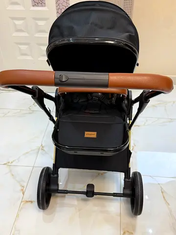 Lightweight black baby stroller with brown leatherette handle — good condition