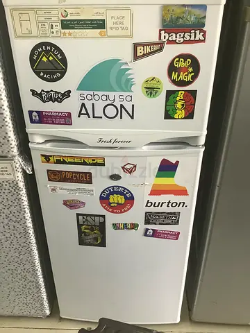 Compact double-door refrigerator/freezer with stickers - good working condition