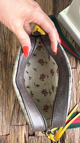 Gucci crossbody bag with floral interior and colorful strap