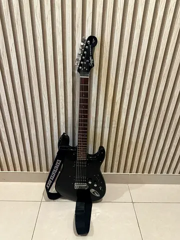 Black electric Squier guitar with strap — good condition