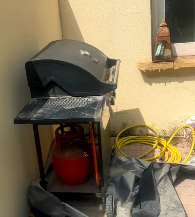 Used outdoor gas BBQ grill with propane cylinder