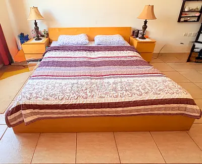 King size wooden bed with headboard and two bedside tables