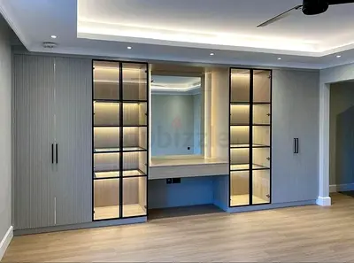 Built-in bedroom wardrobe with illuminated display cabinets and vanity desk