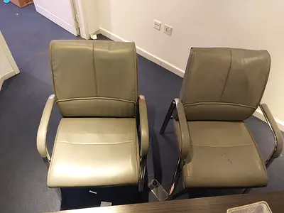 Grey leather office chairs with armrests - used