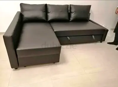 L-shaped black faux leather sofa with storage, good condition